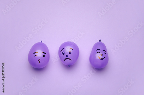 Balloons with drawn faces on purple background