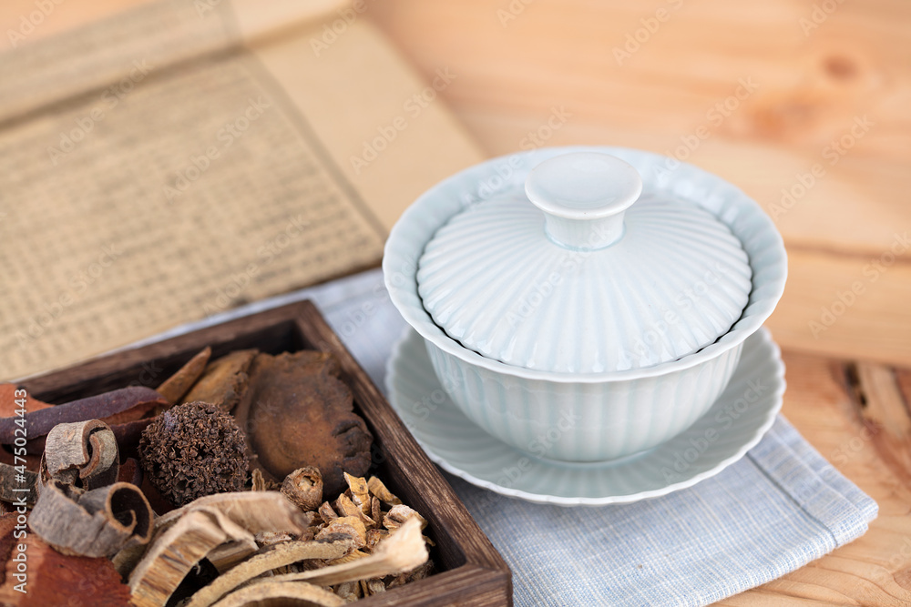 Fototapeta premium The wooden box is filled with traditional Chinese medicine and medicine books and tureen