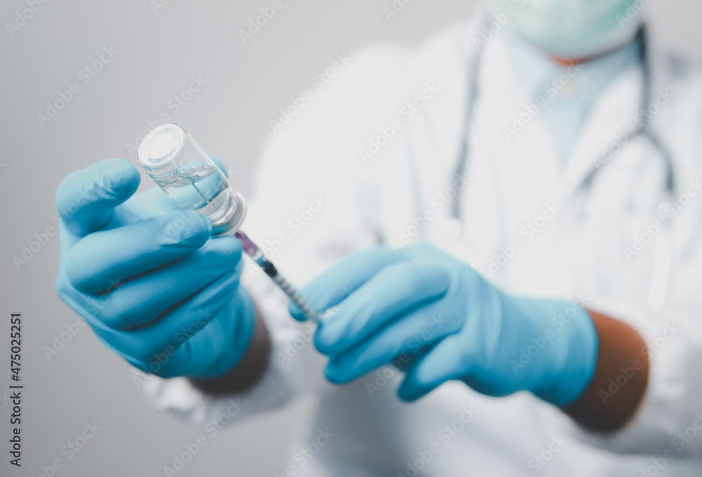A doctor or scientist in the COVID-19 medical vaccine research and development laboratory holds a syringe with a liquid vaccine to study and analyze antibody samples for the patient.
 - obrazy, fototapety, plakaty 