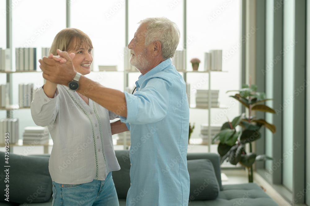 Obraz premium Happy Caucasian senior couple dancing at home