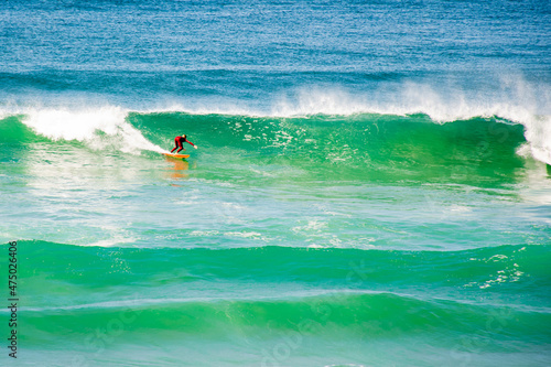 Surfer riding  catching waves in the beautiful turquoise ocean at Cronulla, NSW, Australia.