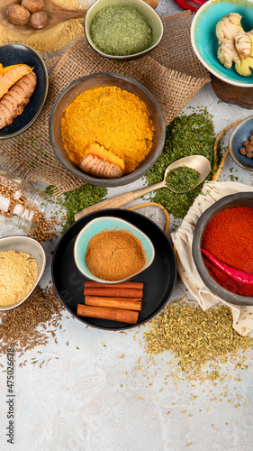 Assortment of Indian spices on gray background.