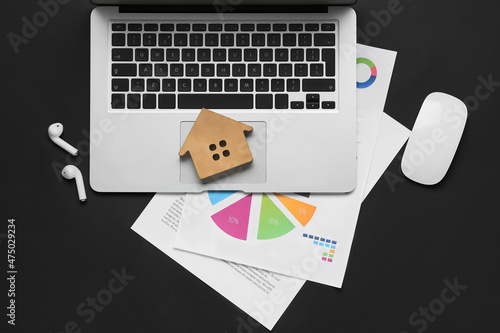Laptop with wooden house, e...