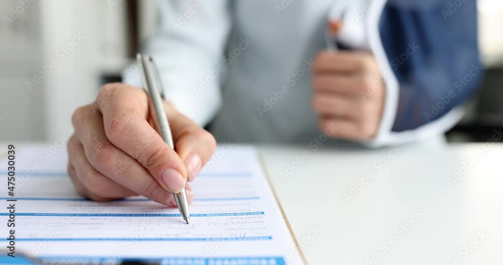 Client with hand injury fills out health insurance claim form Client with hand injury fills out health insurance claim form