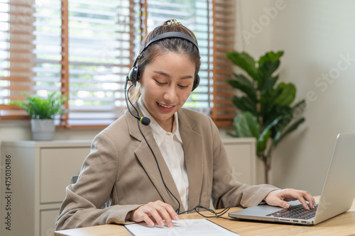 Operator, smile asian young woman wearing headset, headphones and speaking on video call conference with customer, colleagues support phone, work on laptop computer.Technology of help, consult service