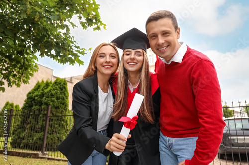 Happy young woman with her parents on graduation day photo