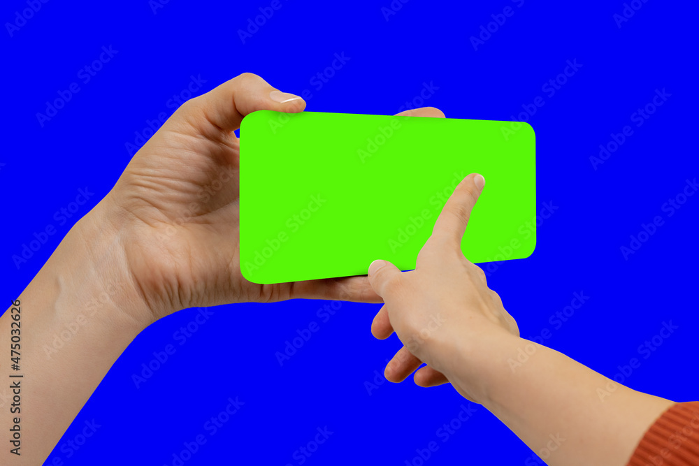 Young woman swiping up on green chroma key smartphone display, the device is positioned slightly turned Young woman swiping up on green chroma key smartphone display, the device is positioned slightly turned