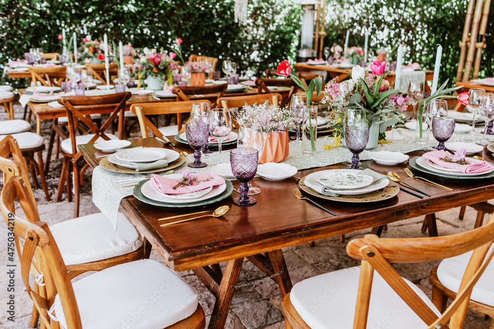 Terrace with tables setup with flowers and plates on table decorated for Wedding Reception in Latin America