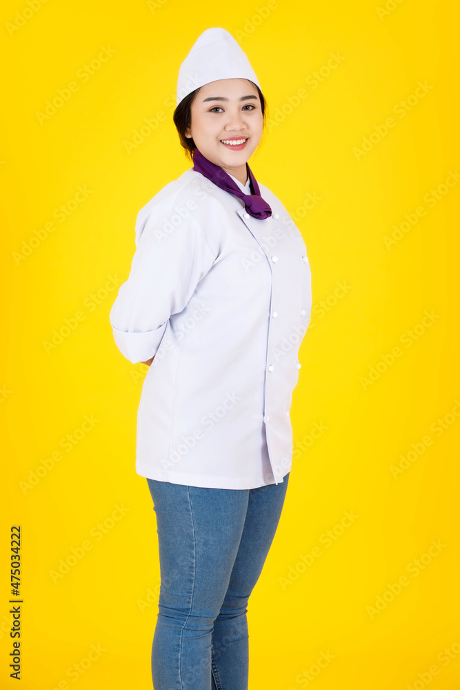 Portrait studio shot of Asian professional successful smart confident hotel restaurant female executive chef in white cooking uniform standing smiling look at camera crossed arms on yellow background Portrait studio shot of Asian professional successful smart confident hotel restaurant female executive chef in white cooking uniform standing smiling look at camera crossed arms on yellow background