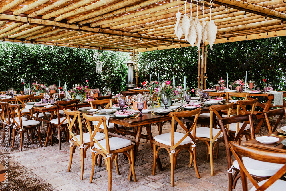 Terrace with tables setup with flowers and plates on table decorated for Wedding Reception in Latin America