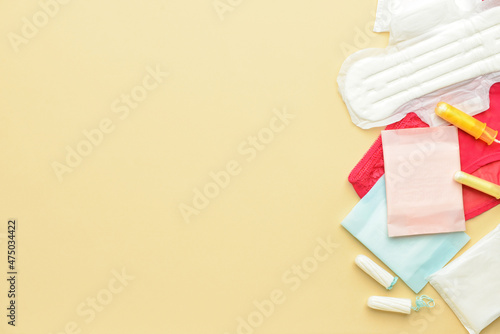 Menstrual pads, tampons and panties on yellow background photo