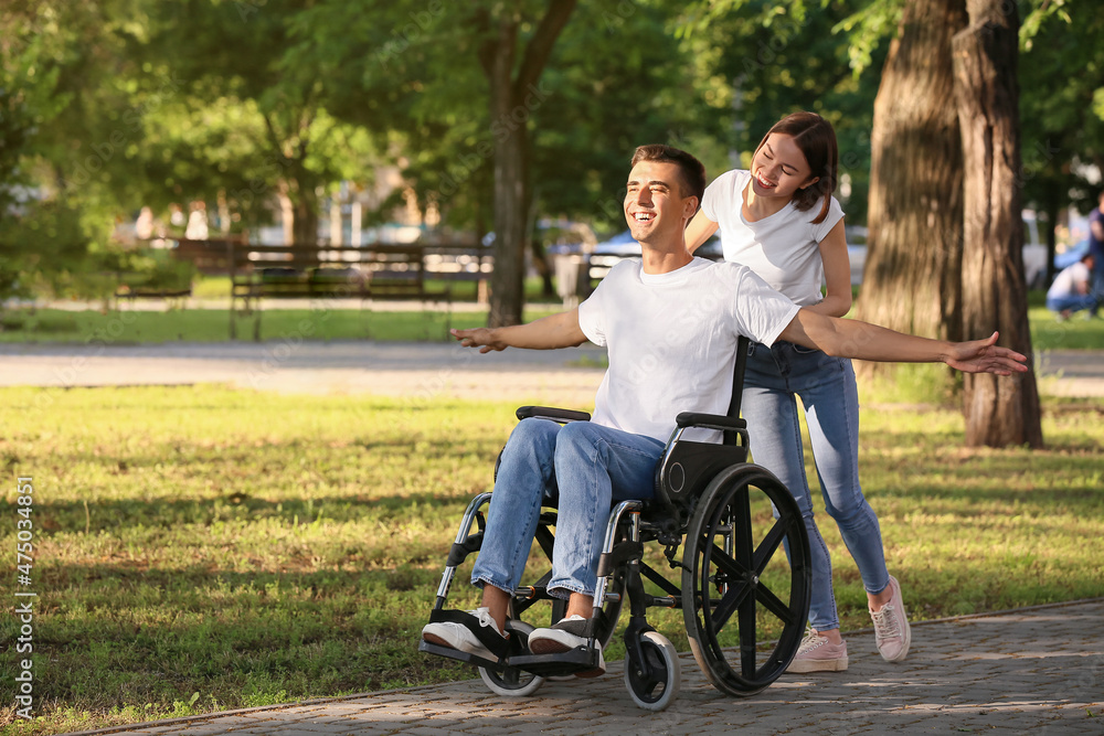 Young man with physical disability and his wife in park Young man with physical disability and his wife in park