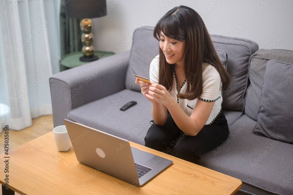 Young beautiful woman is using credit card for online shopping on internet website at home, e-commerce concept Young beautiful woman is using credit card for online shopping on internet website at home, e-commerce concept