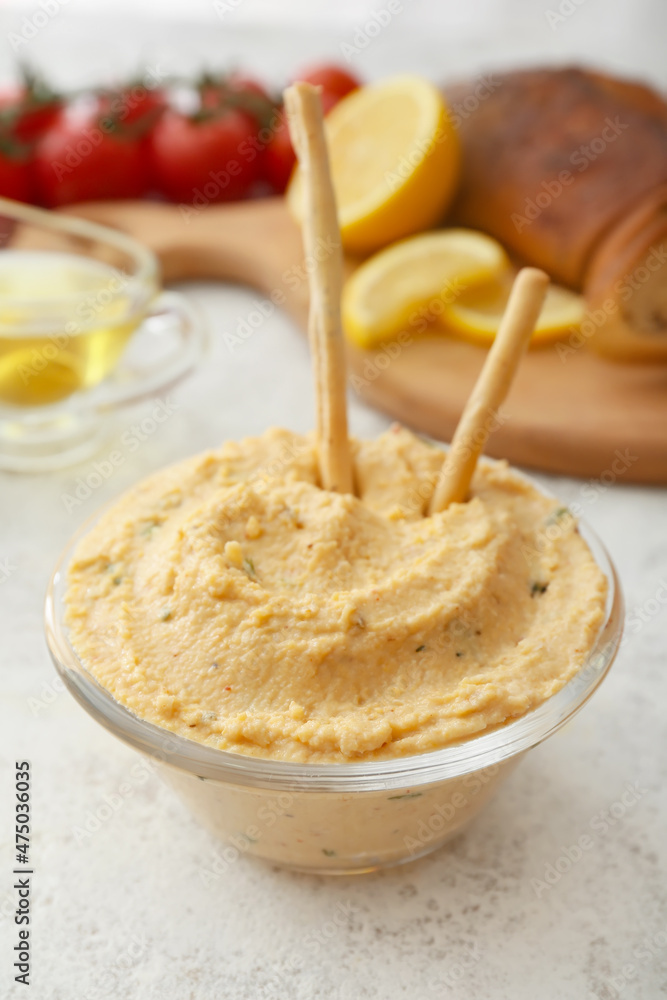 Bowl with delicious hummus and crackers on light background, closeup Bowl with delicious hummus and crackers on light background, closeup