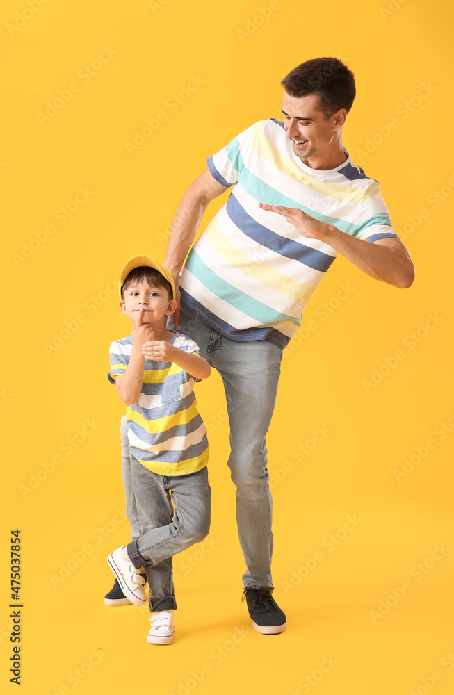 Dancing man and his little son on color background Dancing man and his little son on color background