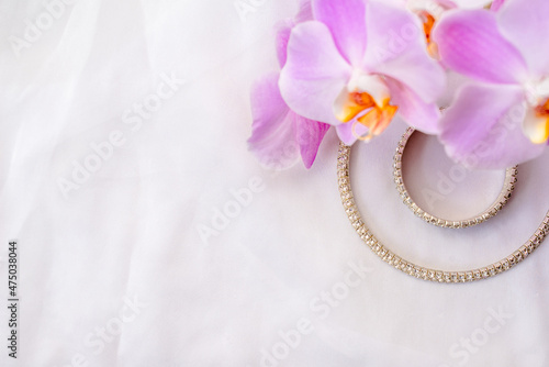 Bracelet and necklace on white fabric and purple Orchid 