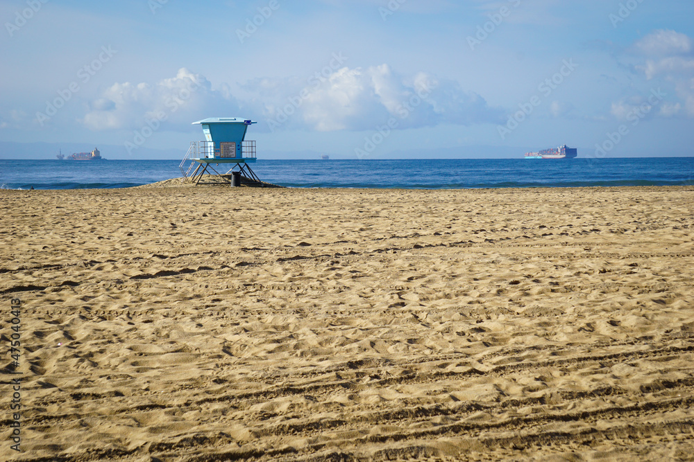 Lifeguard tower on beach with cargo ship in distance