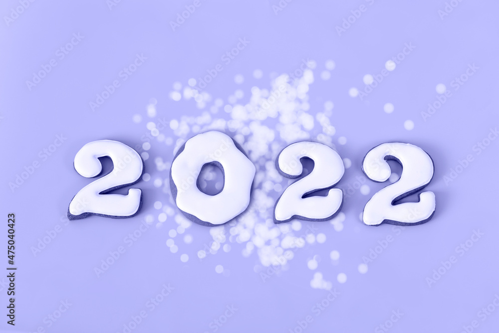 New Year's set of white gingerbread numbers 2022 toned in trendy very peri color. Isolated on very peri background. Top view. New Year's set of white gingerbread numbers 2022 toned in trendy very peri color. Isolated on very peri background. Top view.