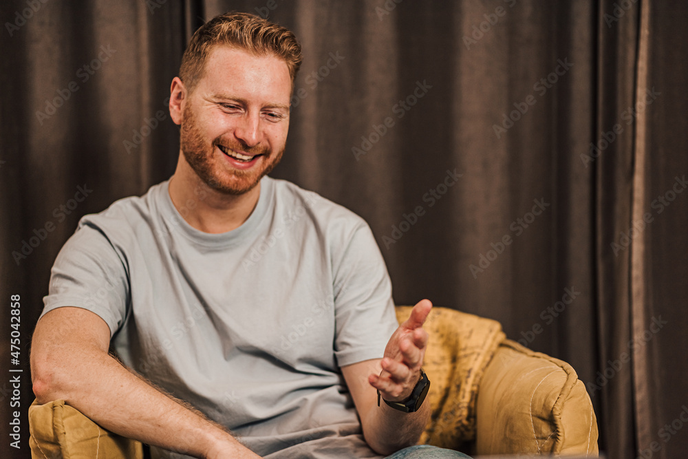 Portrait of man watching tv or online video and reacting or listening to a friend and commentating Portrait of man watching tv or online video and reacting or listening to a friend and commentating