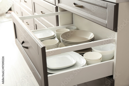 Clean dishes in kitchen drawer, closeup