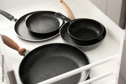 Different frying pans in open kitchen drawer, closeup