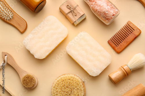 Set of bath supplies with sponges on beige background