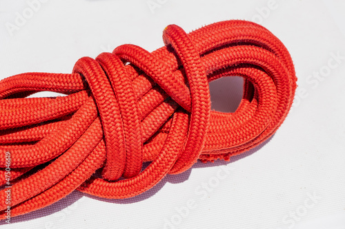 Yachting rope on ship deck. Mooring rope red color on the sailing boat bow background.