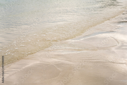 transparent water ripple and sunlight glare on white sand background