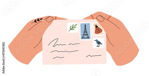 Paper envelope with postage stamps in hands. Person hold received handwritten...