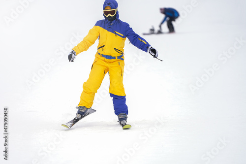 A girl is learning to ski. She glides uncertainly along the snow-covered slope. Selective focus.