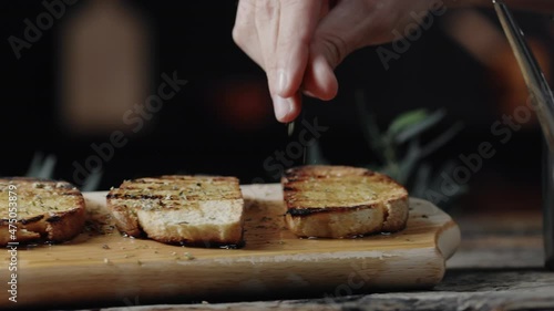Bruschette di pane con olio e origano su tagliere di legno photo