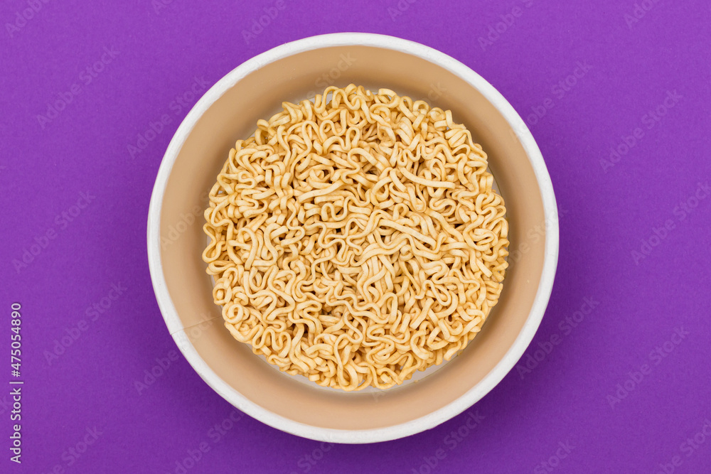 Opened Package with Uncooked Instant Noodles on Violet Background. Raw Pasta. Dry Asian Fast Food. Quick Lunch Opened Package with Uncooked Instant Noodles on Violet Background. Raw Pasta. Dry Asian Fast Food. Quick Lunch