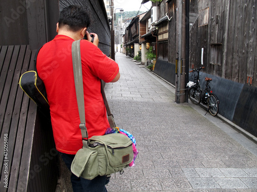 Thai men photographer people travel visit shooting take photo house home retro vintage japanese style on Hanamikoji Street small alley of Gion old town at Kyoto city on July 11, 2015 in Kansai, Japan photo