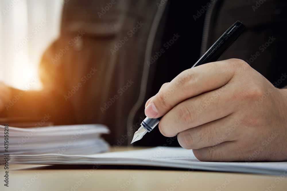 Close up of businessman hand signing document with pen. Business concepts on investment contracts, agreements, and approvals, MOU. Close up of businessman hand signing document with pen. Business concepts on investment contracts, agreements, and approvals, MOU.