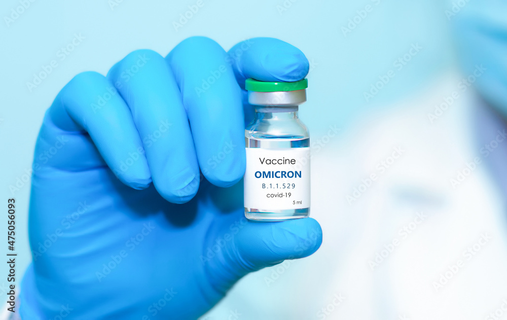 A doctor in medical gloves and a protective mask holds a bottle with coronavirus Covid19 Omicron variant strain vaccine.The concept of medicine, healthcare and science.Coronavirus vaccine A doctor in medical gloves and a protective mask holds a bottle with coronavirus Covid19 Omicron variant strain vaccine.The concept of medicine, healthcare and science.Coronavirus vaccine