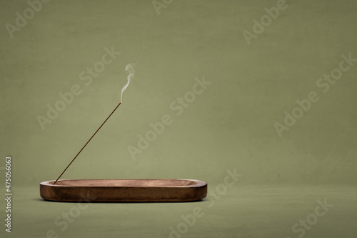 Smoking incense stick in a wooden holder photo