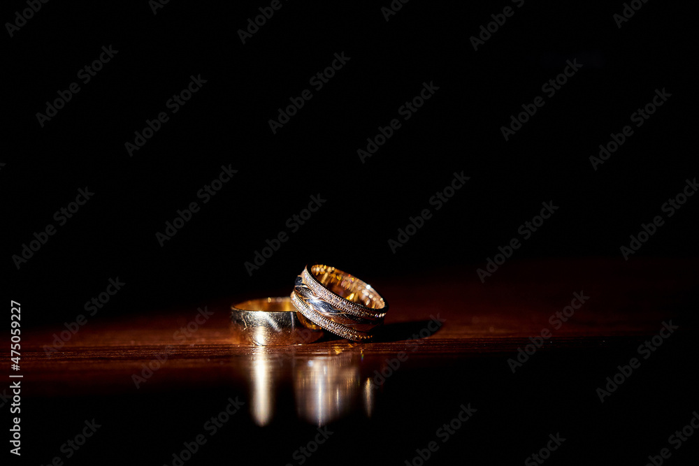 wedding rings with an ornament lie on a wooden background wedding rings with an ornament lie on a wooden background
