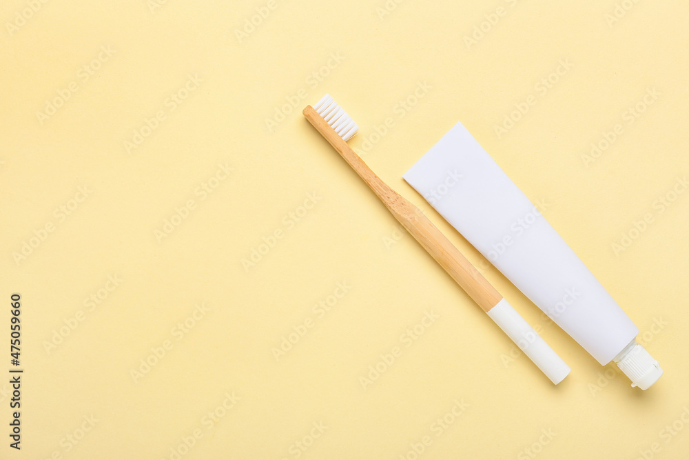 Obraz premium Wooden toothbrush and paste on color background