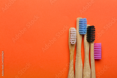 Wooden toothbrushes on orange background  closeup