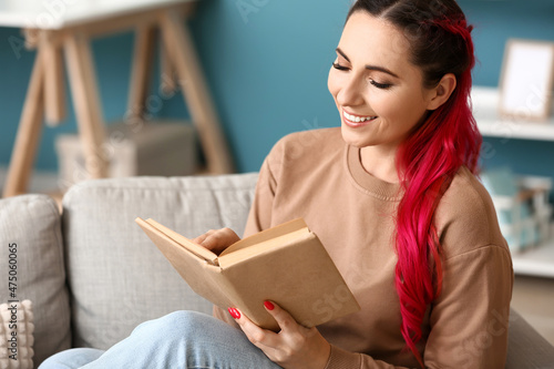 Beautiful woman reading book on sofa at home