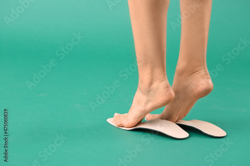 Female feet and orthopedic insoles on green background © Pixel-Shot