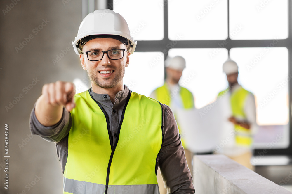 architecture, construction business and building concept - happy smiling male architect in helmet and safety west at office architecture, construction business and building concept - happy smiling male architect in helmet and safety west at office