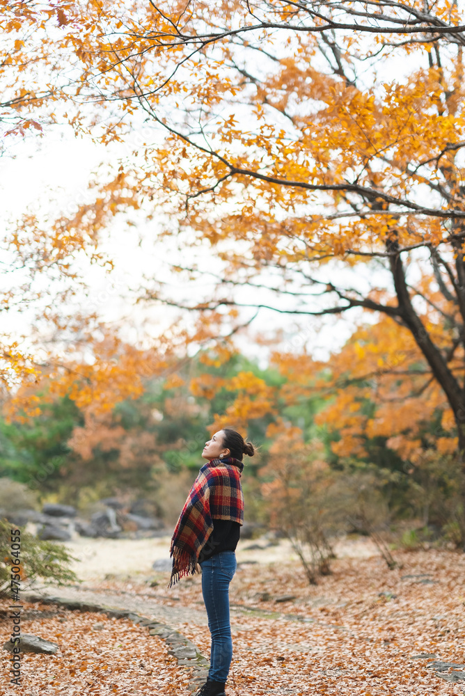 紅葉の公園で遊ぶ女性