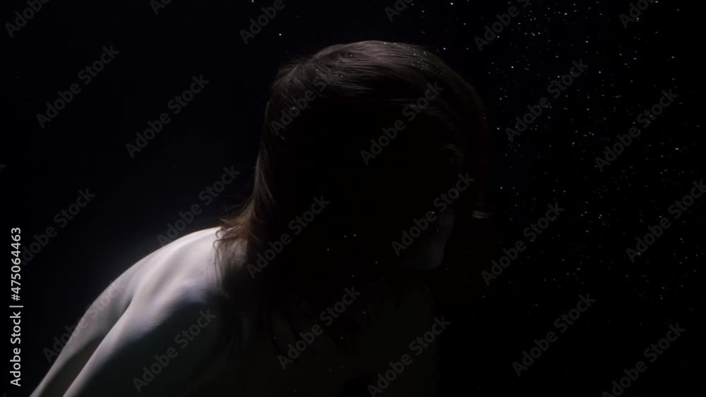 close-up of a woman's head and bare shoulders in dark water close-up of a woman's head and bare shoulders in dark water
