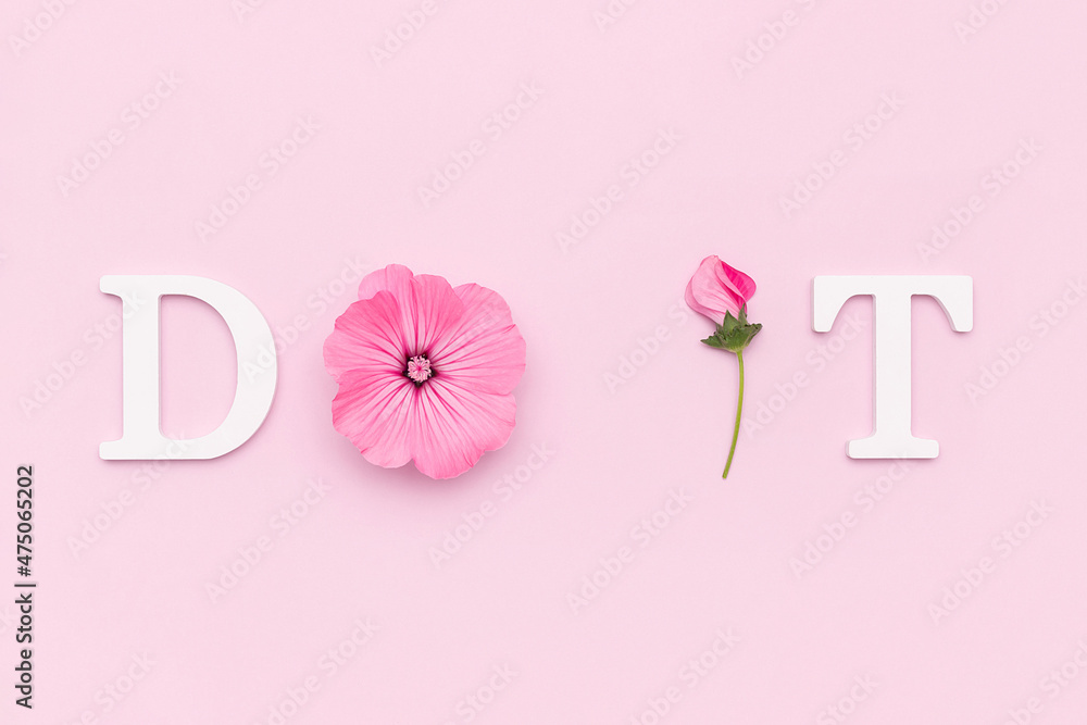 Do it. Motivational quote from white letters and beauty natural flowers on pink background. Creative concept inspirational quote of the day