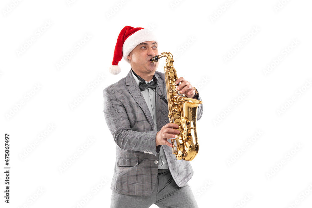 Fototapeta premium Elegant adult man wears in Santa's hat plays on saxophone on white background. New Year party 