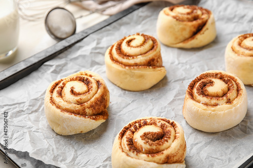 Baking dish with uncooked cinnamon rolls on light background, closeup