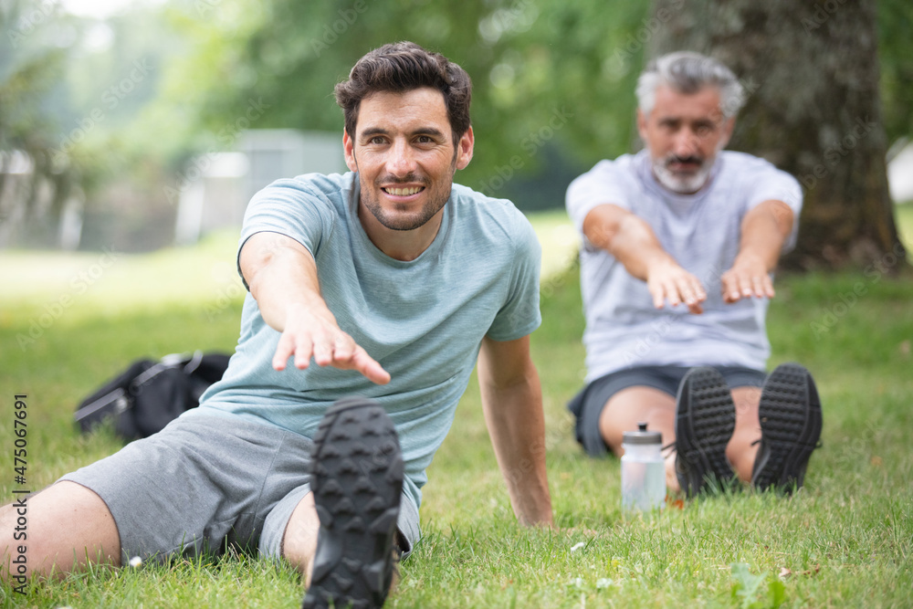 two men sitting and exercising in the garden two men sitting and exercising in the garden
