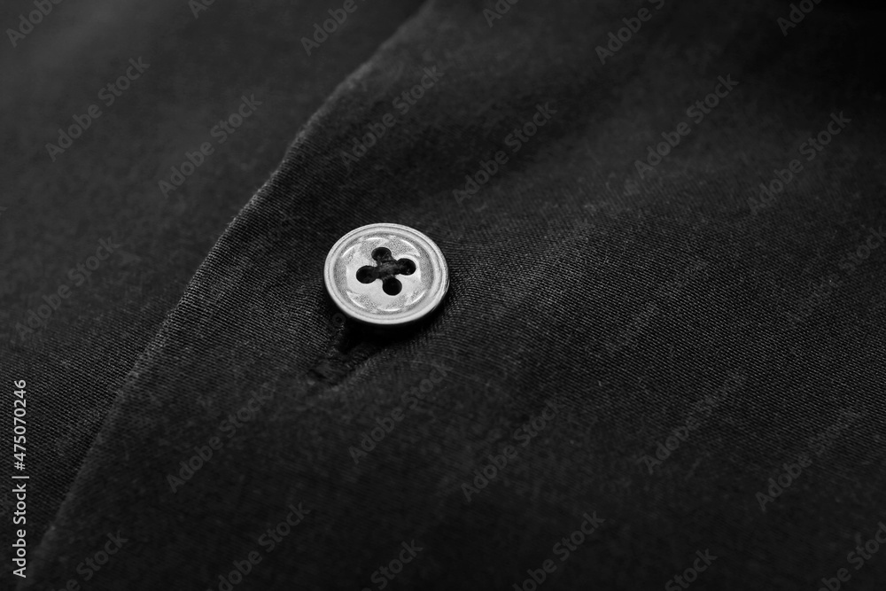 Closeup view of button on black linen shirt Closeup view of button on black linen shirt