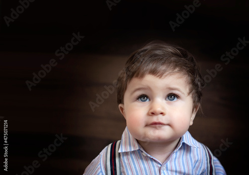 Bebé ojos azules en fondo de madera  photo